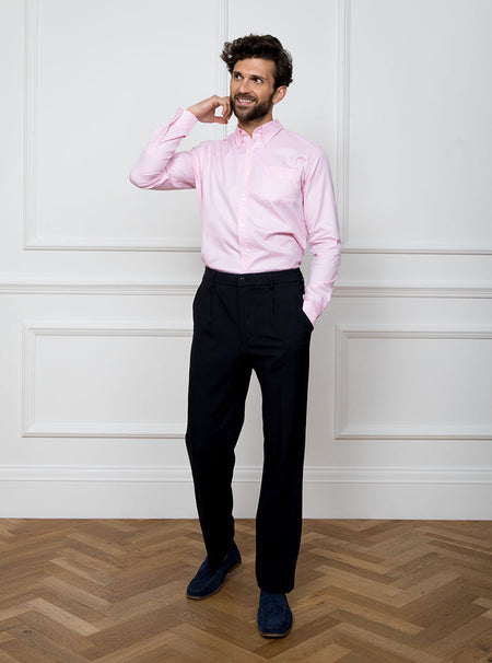 Man wearing a pale pink long sleeved shirt with a button down collar made with 100% Royal Oxford Cotton.